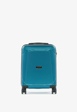 Twarda niebieska walizka kabinowa na czterech czarnych kółkach obrotowych i z górnym uchwytem, oznaczona prostokątną tabliczką z logo OCHNIK.