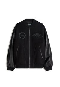 Fekete bombázódzseki kontrasztos bőrujjakkal, cipzáras zsebekkel, és díszítő hímzéssel, amelyen a "HOPELESSLY ADAPT" felirat és egyéb minták láthatók.