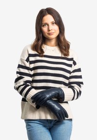 Striped knit sweater in cream and navy, with a ribbed hem. Soft, fitted leather gloves in dark blue, complementing the outfit.