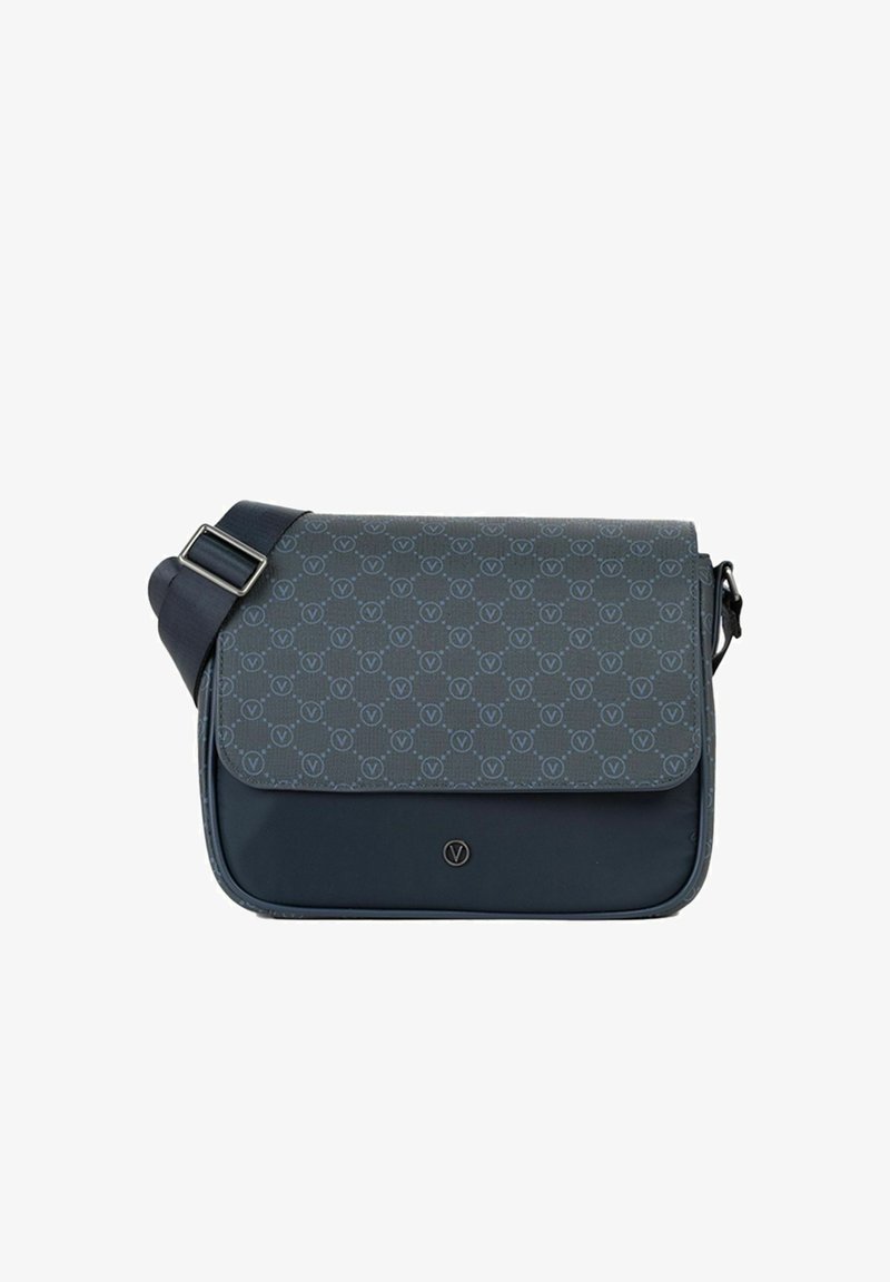 Sac bandoulière bleu foncé avec sangle réglable, fermeture à rabat ornée d'un motif répétitif de logos circulaires et d'un petit emblème métallique circulaire.