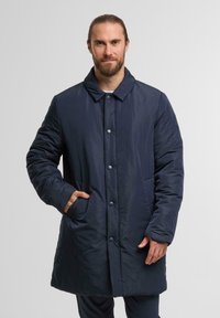 Navyblauer, isolierter langer Mantel mit Kragen, Knopfverschluss, seitlichen Taschen und glatter Außentextur. Geeignet für kaltes Wetter.