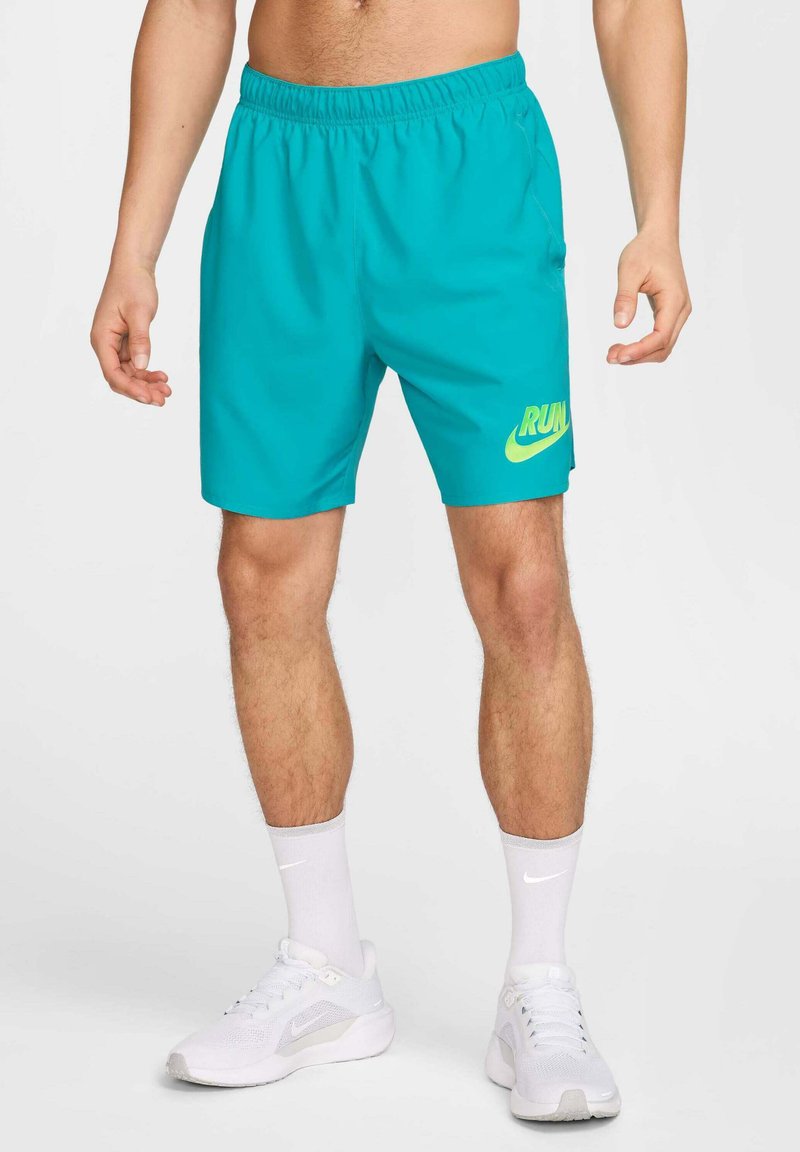 Pantalones cortos deportivos turquesa con una cinturilla elástica, que presentan un logo en amarillo neón que dice "RUN" en la pierna izquierda. Textura ligera y suave.