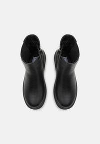 Sorte lær ankle boots med en glat overflade, sidelukninger og en rund tådesign. Indersiden er foret med blødt materiale.