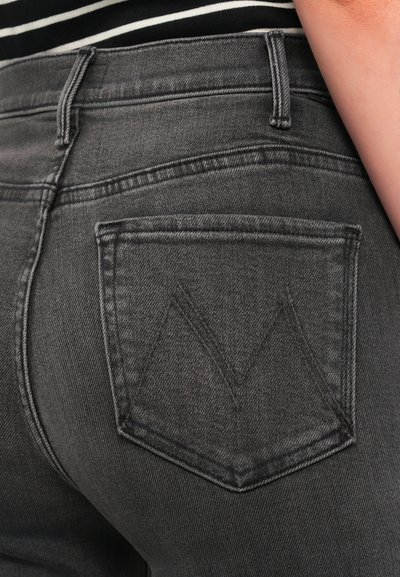 Skinny jeans in dark gray denim featuring a back pocket with a triangular stitching design and subtle fading at the seams.
