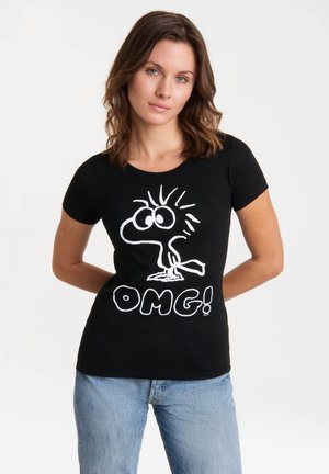 Black cotton t-shirt featuring a white cartoon character with large eyes and spiky hair, accompanied by the text "OMG!" in bold letters.