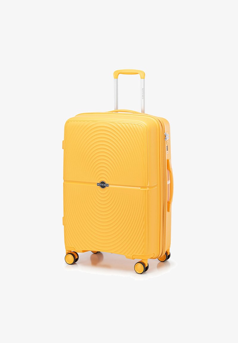 Maleta rígida amarilla con patrón de olas, mango extensible, cuatro ruedas giratorias y un mango lateral. Presenta una placa de logo negra.