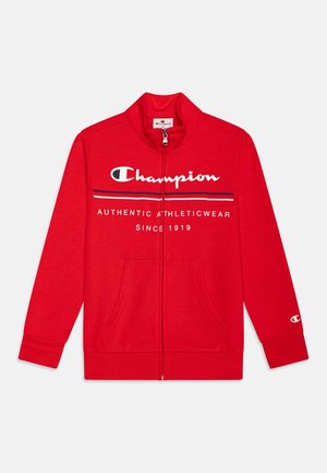 Veste Champion rouge à fermeture éclair complète avec texte de logo blanc et noir "Champion Authentic Athleticwear Since 1919" et poches avant.