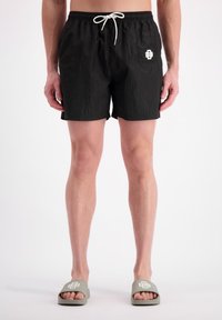 Zwarte zwemshorts met elastische tailleband en trekkoord, voorzien van een zijzak en een witte logotrim aan de voorkant links. Glad materiaal.