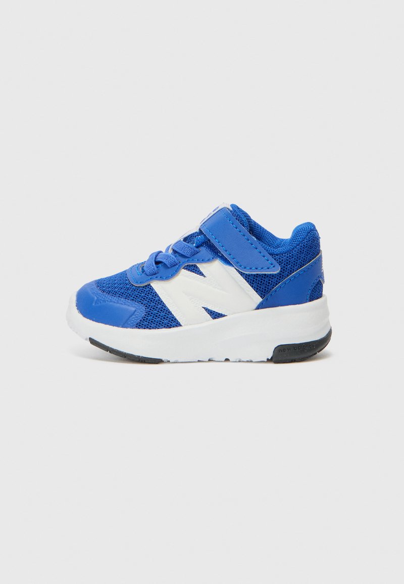 Chaussure de sport bleue avec tige en mesh, accents blancs et sangle auto-agrippante. Elle présente un bout arrondi, une semelle rembourrée et une semelle en caoutchouc à motif.