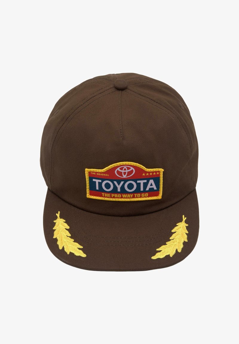 Căciulă de baseball maro cu patchul logo Toyota și desene brodate cu frunze galbene pe bor.