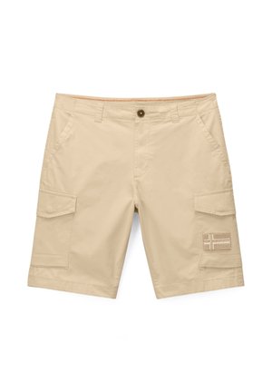 Beżowe szorty cargo z bocznymi kieszeniami na klapę i zapięciem na guzik, z naszywką z motywem krzyża na prawej kieszeni nogawki.