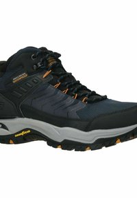 Schwarzer wasserdichter Wanderschuh mit Obermaterial aus Netz und Synthetik, orangefarbene Akzente, robuste graue Sohle und strukturierte Schnürsenkel für einen sicheren Sitz.