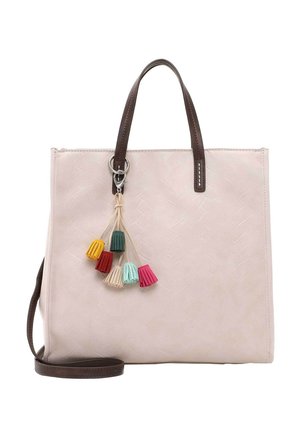 Kremowa torba na ramię z ciemnobrązowymi uchwytami i paskiem, ozdobiona kolorowym brelokiem z frędzlami w kolorach żółtym, czerwonym, kremowym, turkusowym i różowym.