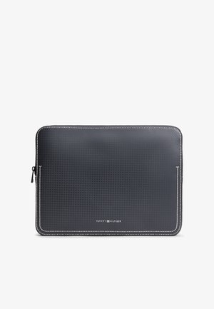 Zwart gestructureerde rechthoekige laptoptas met witte stiksels en rits aan de linkerkant, "Tommy Hilfiger" logo gecentreerd onderaan.