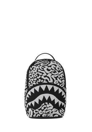 Zaino bianco e nero con motivo astratto animale e grande disegno di bocca con denti appuntiti sulla tasca anteriore.