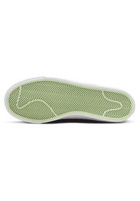 Gummisulor med ett grönt fiskbensmönster, vita kanter och lätt kurvatur för förbättrat grepp och flexibilitet.