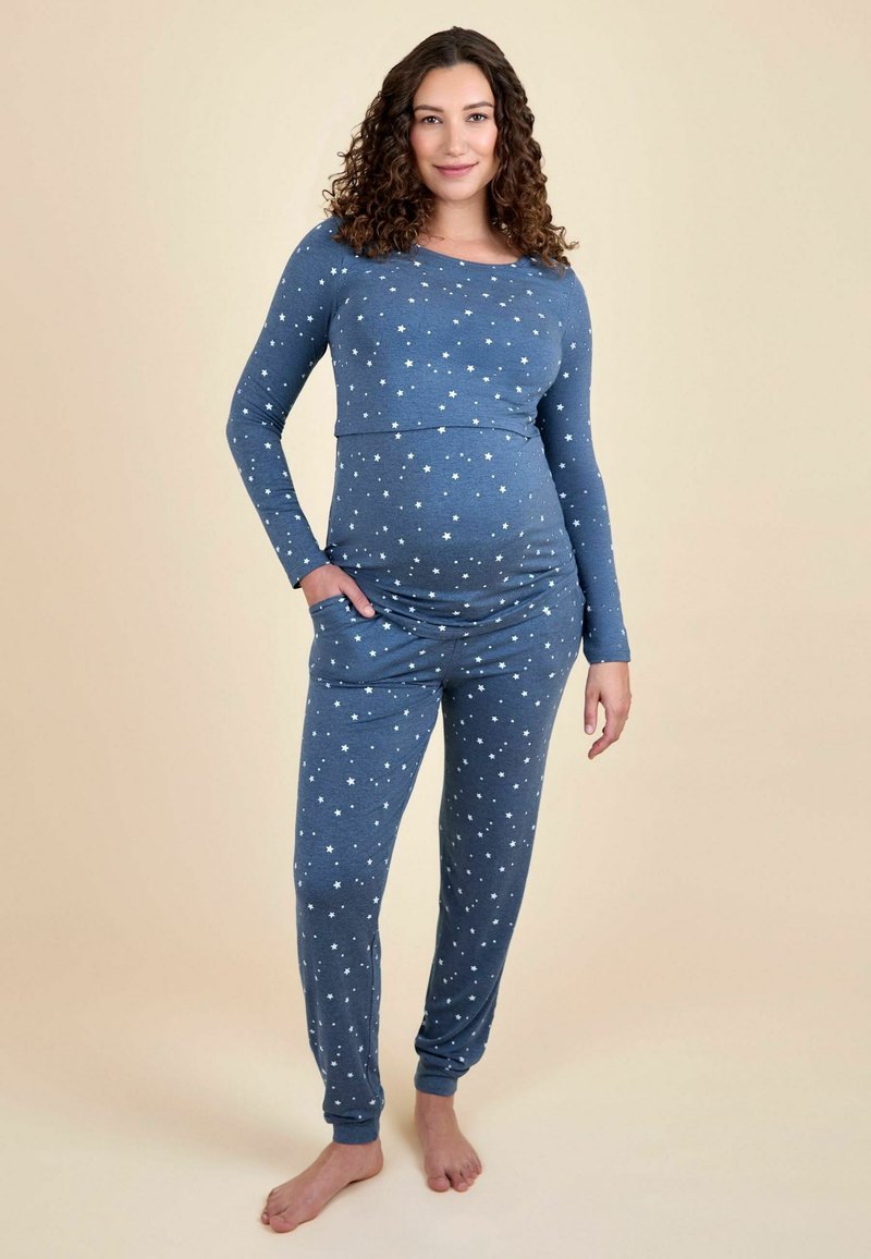 Set de pijamale de maternitate dintr-un material bleu moale, cu modele de stele albe, mâneci lungi, un top ajustat și pantaloni conici cu buzunare.