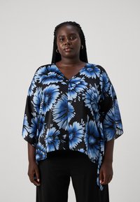 Blomsterbluse i gjennomsiktig svart stoff med store blå blomster. V-hals-design med brede ermer og asymmetrisk kant.