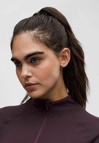 Bordo krāsa ar rāvējslēdzēju, ar augstu apkakli, izgatavots no gludas auduma. Izceļas ar pieguļošu dizainu un šķiet gaisīgs, piemērots aktīvajai apģērbu izvēlei.