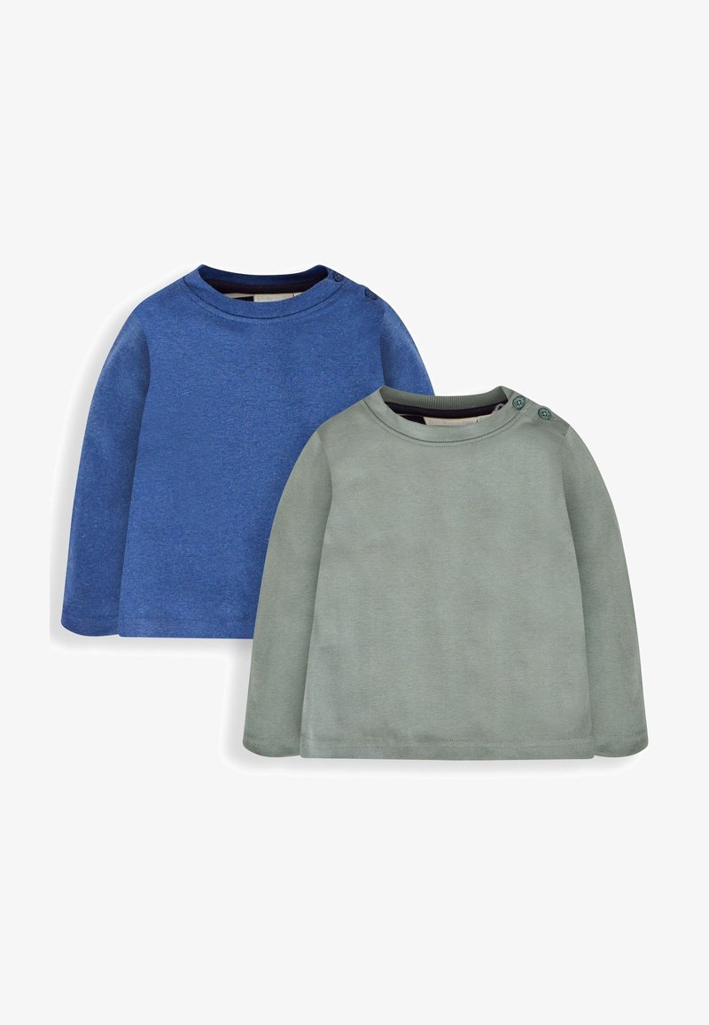 Divas garām piedurknēm krekli: viens zilā krāsā, otrs gaiši zaļā krāsā. Abi izgatavoti no mīkstas teksturētas auduma, ar ribotām apkaklēm, zaļā kreklā ir pogas.