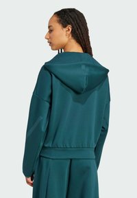 Teal mikina s kapucňou s uvoľneným strihom, hladkou textúrou a jemným leskom, s rebrovaným lemom a manžetami.