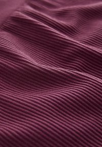 Strukturiertes Stoffmaterial in tiefem Burgunderrot mit feinen, horizontalen Rippungen, die weiche, wellenartige Bewegungen erzeugen. Glatte Oberfläche mit subtiler Schimmer.