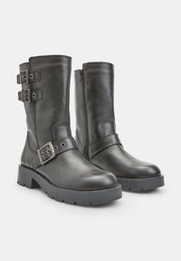 Mustad must ja kõrge säärteta nahkkingad külgsiibiga, kaks reguleeritavat rihma ja pandlad ning tugev kummitald. Ühtlane sile tekstuur.