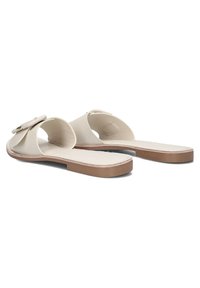 Beige schuiflippers met een brede bovenband en ronde uitsparing. Platte zool met een lichtbruine buitenzool. Gladde textuur, minimalistisch ontwerp.