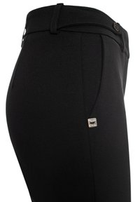 Pantaloni neri realizzati in un tessuto liscio, con un design elegante, una vestibilità dritta e un piccolo etichetta del marchio in argento sul lato.