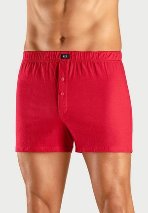 Rote Baumwoll-Boxershorts mit elastischem Bund, ausgestattet mit einem Knopfverschluss vorne und einer glatten Textur. Etikett am Bund sichtbar.