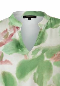 Kurzarmbluse aus leichtem Stoff mit V-Ausschnitt, die ein Aquarell-Blumenmuster in grünen und pinken Farbtönen zeigt. Etikett: MORE&MORE.