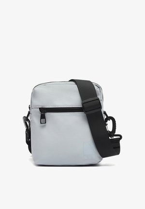 Kompaktna pravokutna svijetlosiva torbica na rame s prednjim džepom na patentni zatvarač i širokom podesivom crnom naramenicom na bijeloj pozadini.