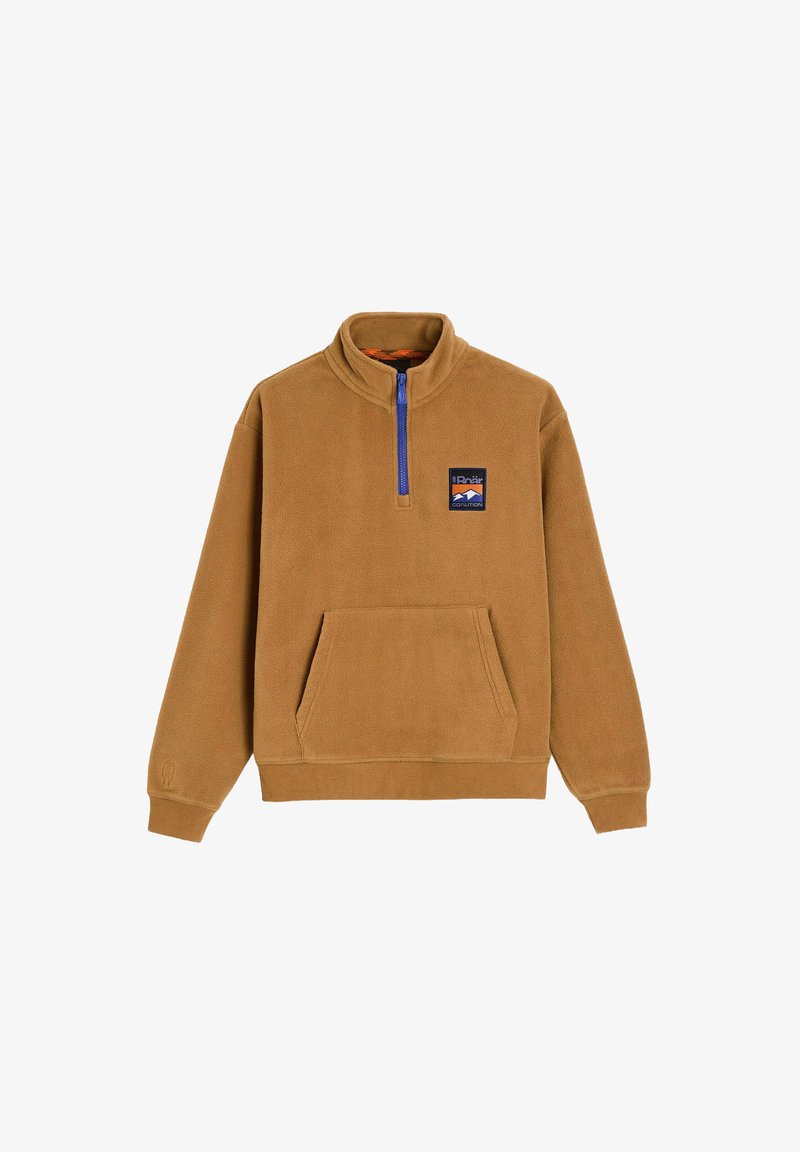 Brązowy polarowy pulower z półzamkiem przy kołnierzu, przednią kieszenią i niebieskim zamkiem błyskawicznym. Ma naszywkę z logo na lewej piersiach. Miękka faktura.