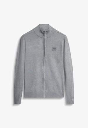 Sivi kardigan na zip od pletene tkanine. Ima visoki ovratnik, rebraste manžetne i donji rub, s malom logom oznakom na prsima.