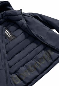 Giacca puffer blu navy con interno trapuntato, caratterizzata da un logo prominente sulla fodera e una superficie esterna liscia. Include zip e tasche.