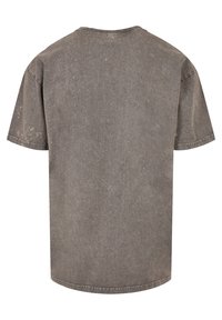 Gray oversized t-shirt with a round neck, short sleeves, and a slightly textured finish. Distressed look with subtle variations in tone.