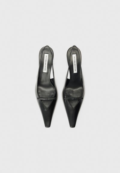 Črne usnjene slingback čevlje z ošiljenim nosom, ki imajo angularno izrezano zasnovo in majhno pentljo kot okras na vampu.