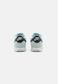 Sneakers Nike in suede blu chiaro, dettagli neri e suola bianca. Presentano un colletto imbottito e un logo a contrasto sul tallone.