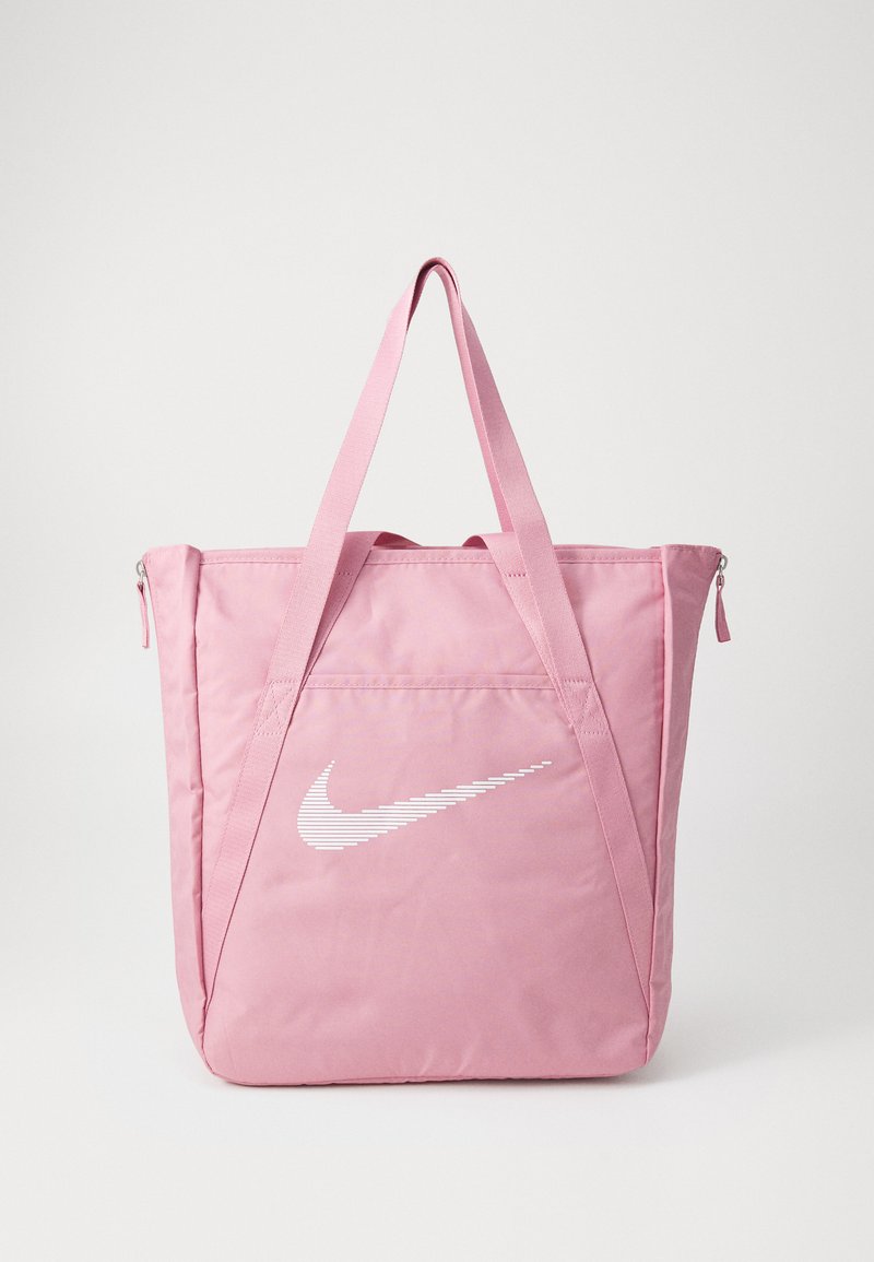 Geantă tote din nailon roz, cu două curele din material textil, având un logo alb Nike și un buzunar cu fermoar, de formă rectangulară compactă, cu o textură netedă.