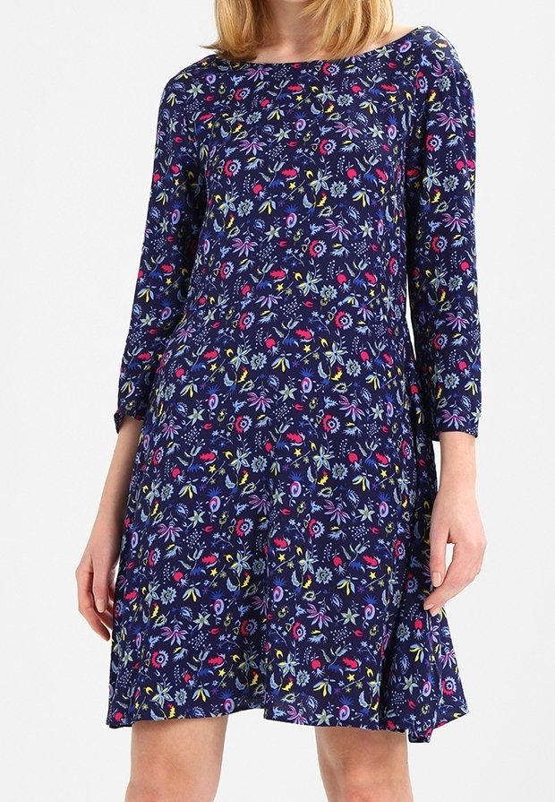 Navy blue dress with colorful floral patterns, three-quarter sleeves, a round neckline, and a flared silhouette. Made of soft fabric.