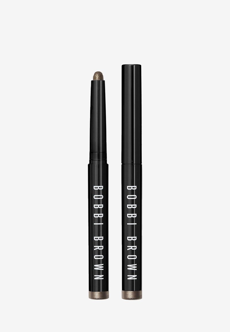 Bobbi Brown oogstift in zwarte verpakking met witte tekst. De punt is afgerond, met een metallic taupekleur. Inclusief twee applicators.