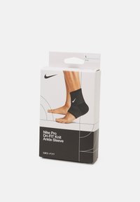 Nike Pro Dri-FIT kötött boka rézsű fekete színben, texturált kötésű dizájnal és logóval, csomagolt dobozon bemutatva. Méret: L.