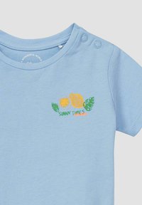 Lichtblauw babyshirt met citroengrafiek, groene bladeren en de tekst "Zonnige tijden voor de boeg" op de borst nabij de knoopschouder.