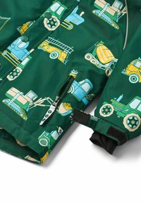 Giacca impermeabile verde con un motivo di camion e veicoli da costruzione. Presenta una tasca con zip e un cinturino in velcro sul polsino.