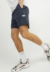 Navy blue sportshorts met een ritzak, gemaakt van een zachte stof. Beschikt over een logo-opdruk aan de linkerkant en heeft een getailleerd ontwerp.