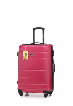 Pink hard-shell suitcase with textured surface, extendable handle, and four black wheels. Tag features a pineapple design.