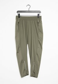 Pantaloni verde oliva con vita elasticizzata e tasche laterali con zip appesi a una gruccia nera su uno sfondo bianco.