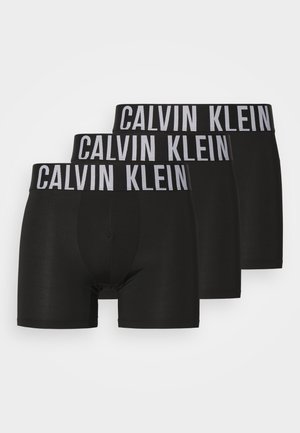 Boxers pretos feitos de tecido elástico, com uma cinta larga com "Calvin Klein" impresso em branco. Conjunto inclui três pares.