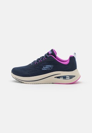 Granatowy sneaker z różową podszewką, beżową podeszwą z widoczną poduszką powietrzną, cholewką z siateczki i zapięciem na sznurowadła, pokazany z boku.