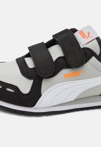 Sort og grå sneaker med velcro-stropper, hvide accenter, struktureret læder og et markant orange logo. Har et sporty design.